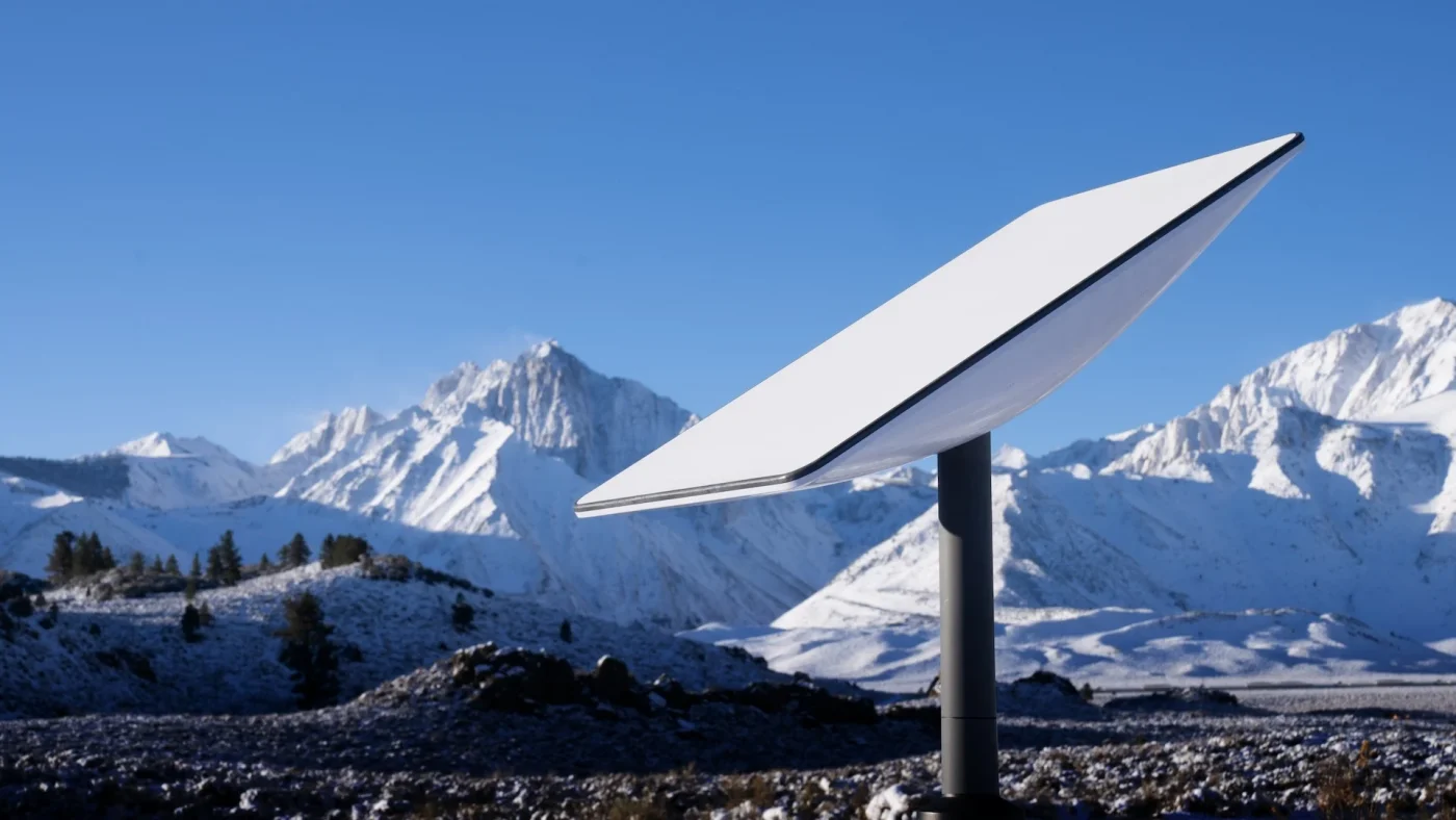 Antenne Starlink installée dans une zone reculée, entourée de montagnes et de nature.
