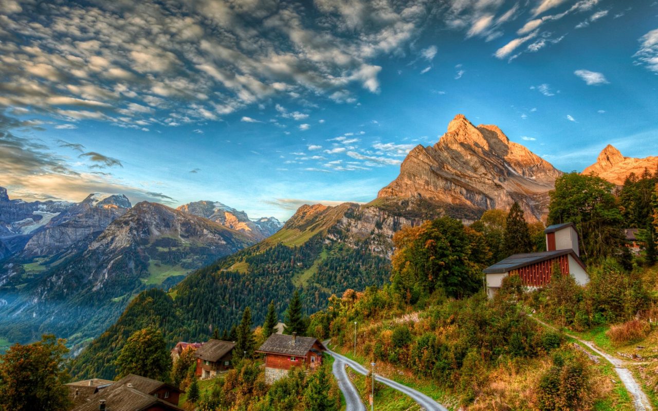 Vue d’un village suisse en montagne avec des chalets traditionnels, illustrant les zones reculées où notre service d’installation Starlink permet un accès Internet haut débit